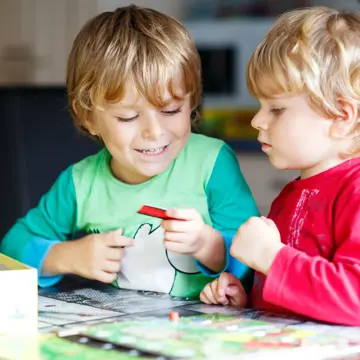 Two Boys Playing A Board Game Gettyimages 882967098