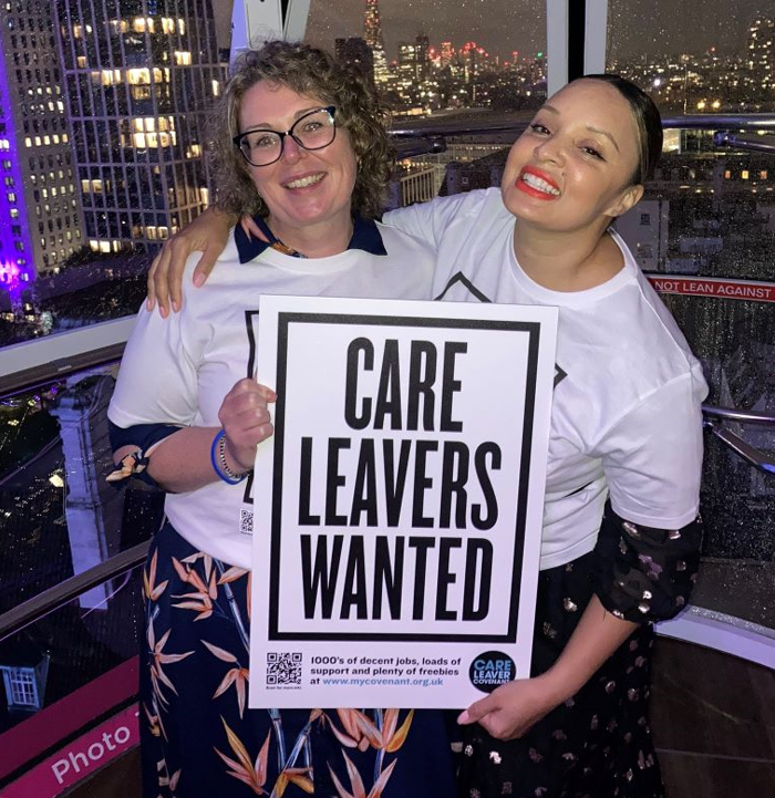 Chief executive of The Fostering Network, Sarah Thomas, stands in London Eye pod with Heart radio presenter, Pandora Christie, holding Care Leavers Wanted poster 